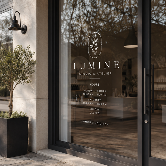 Outdoor window decal applied to a boutique storefront glass door with logo and business hours